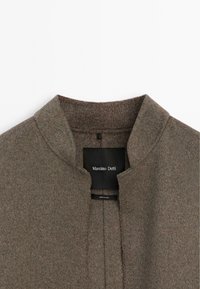 Brown wool coat with a high collar, featuring a clean front design and a black label showing the brand name Massimo Dutti.
