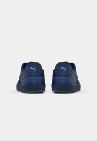 Navy blue sneakers with textured rubber outsole, padded collar, and blue stitching. Features logo on heel and smooth synthetic upper.