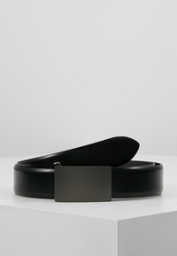 Ceinture en cuir noir avec une boucle rectangulaire en métal texturé. Texture lisse, design plat et longueur adjustable.