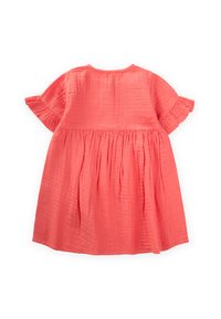 Vestido de color coral hecho de una tela ligera y texturizada con mangas cortas con volantes y detalles plisados en la cintura.