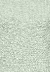 Tissu tricoté vert menthe clair avec un motif en zigzag horizontal texturé et une apparence douce et confortable.