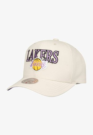 Beige baseball cap with embroidered "LAKERS" text in purple, featuring a basketball graphic. Smooth fabric, curved brim, and adjustable back.