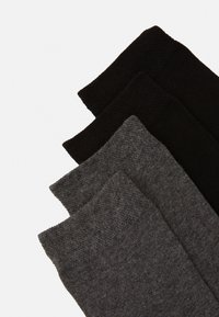 Three pairs of socks in black, dark gray, and medium gray. Ribbed texture at the cuffs, soft fabric, with a smooth body design.