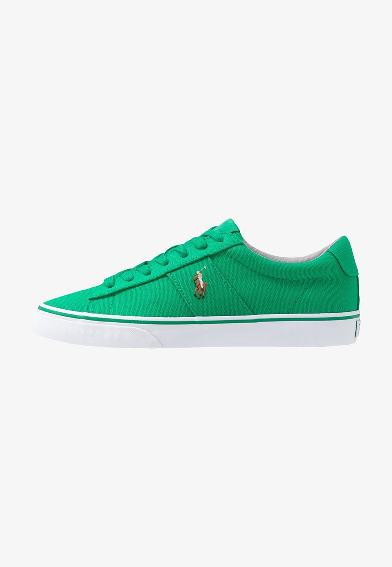 Zapatilla baja de lona verde con suela blanca, una raya verde, cordones y un pequeño logo bordado de jugador de polo en el lateral.