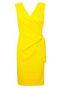 Gul v-ringad klänning med inlindad design och sidoförbindelse. Tillverkad av mjukt tyg, har den en figurnära silhuett och mjuka draperingar vid midjan.