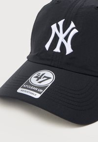 Μαύρο ρυθμιζόμενο καπέλο μπέιζμπολ με λευκό κεντημένο λογότυπο NY και στρογγυλή αυτοκόλλητη ετικέτα '47 Clean Up' στο γείσο.