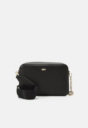 Svart crossbody-veske med teksturert overflate, gullfarge detaljer og kjedeaksent. Har avtakbar stropp og glidelås-lukking. DKNY-logoen er synlig.
