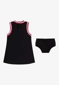 Črna brezrokavnik otroška obleka z rdečimi in belimi črtastimi obrobami, združena z ujemajočimi se črnimi elastčnimi kratkimi hlačami z elastiko v pasu.