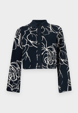 Kuttet knapp-up jakke i marineblått med hvitt blomsterdesign. Laget av myk stoff, har lange ermer og spiss krage.