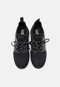 Čern�é sportovní boty vyrobené z textilní síťoviny a syntetických materiálů. Mají strukturovaný svršek, ploché tkaničky a gumovou podrážku. Logo na jazyku boty.