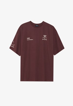 Bordowa koszulka z bawełny, z krótkimi rękawami i okrągłym dekoltem. Graficzne nadruki: palma, fale i tekst na klatce piersiowej oraz rękawie.