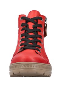 Bottines montantes en cuir rouge à lacets noirs, avec une semelle en caoutchouc beige, des œillets en métal et une fermeture éclair latérale pour un accès facile.