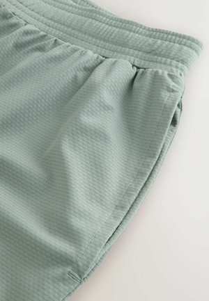 Ţesătură textilă de culoare verde deschis, texturată, cu un model canelat; dispune de un tiv elastic la talie şi cusături strânse pentru o potrivire confortabilă. Stil de pantaloni scurţi casual.
