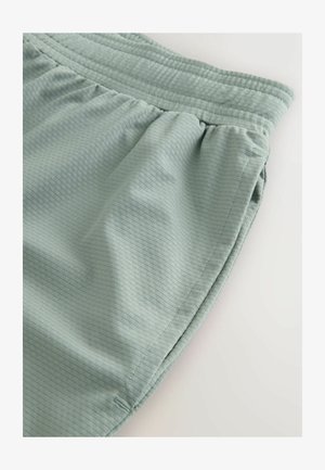 Svetlozelená, textúrovaná látka s ryhovaným dizajnom; má elastický pás a nariasené švy pre lepšie prispôsobenie. Štýl voľnočasových šortiek.