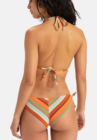 Randig bikini i orange, turkos och bruna nyanser. Topp med halterneck-knytning; bottnar med diagonala ränder och sidoknytningar.