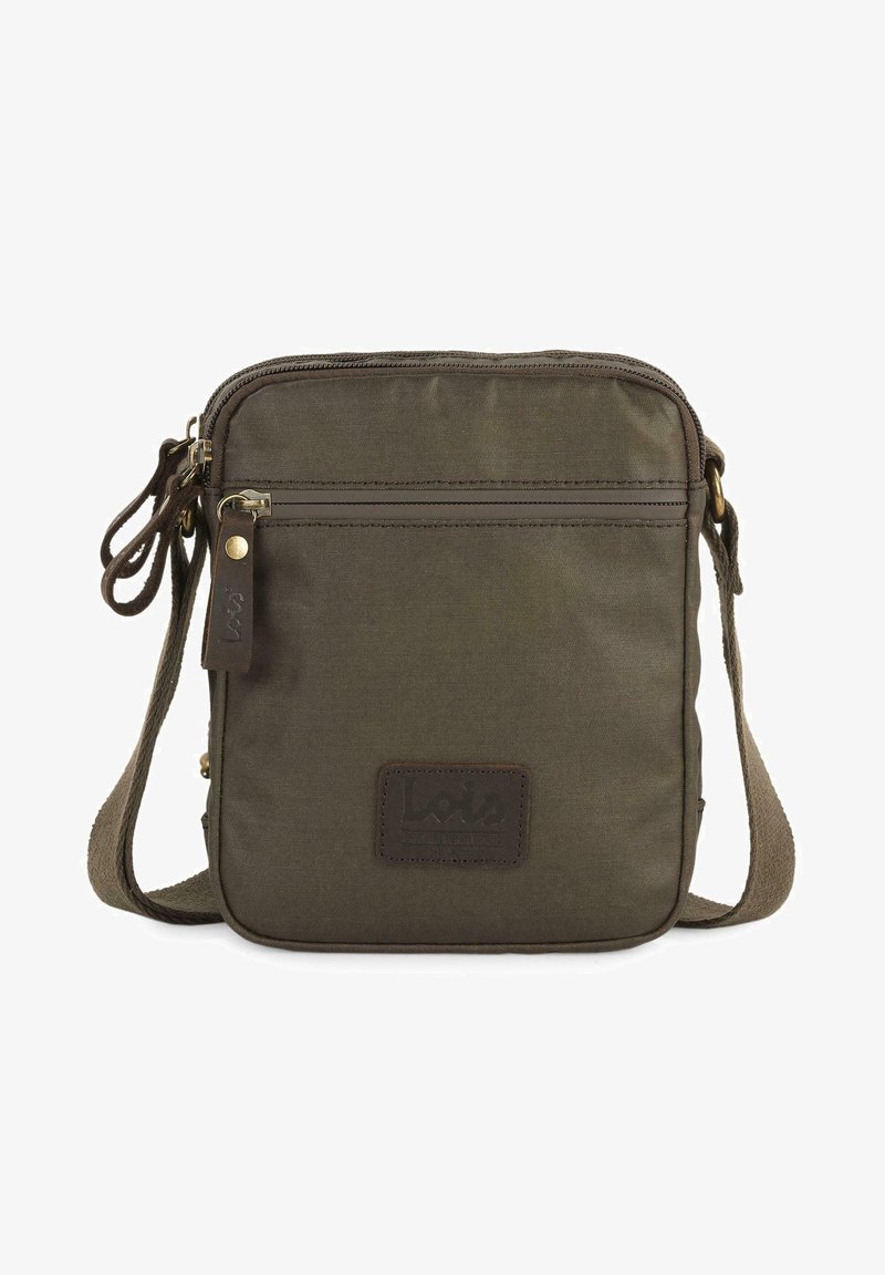 Bolso cruzado color verde oliva hecho de tela, con un compartimento con cremallera, un bolsillo frontal con un parche de cuero con el logotipo y una correa ajustable.