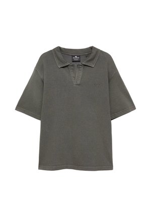 Polo gris foncé à manches courtes avec col ouvert et logo brodé subtil sur le côté gauche de la poitrine, présenté sur fond blanc.