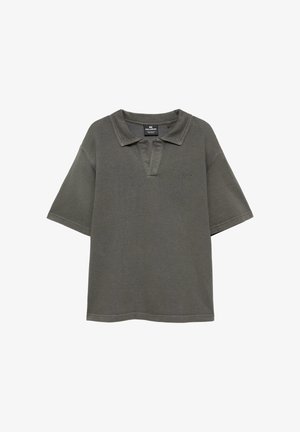 Polo gris foncé à manches courtes avec col ouvert et logo brodé subtil sur le côté gauche de la poitrine, présenté sur fond blanc.