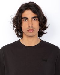 Czarna, długa koszula z długim rękawem, wykonana z bawełny, z okrągłym dekoltem i subtelnym logo na lewej piersi. Gładka tekstura.