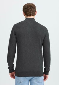 Suéter gris oscuro con mangas largas, puños y cuello acanalados. Textura de punto con una silueta ligeramente ajustada. Vista trasera mostrada.