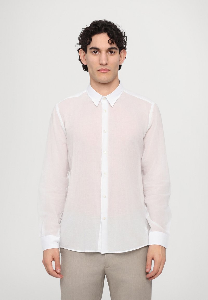 Camisa blanca de botón hecha de tela ligera, con mangas largas, un cuello clásico y una sutil textura transparente.