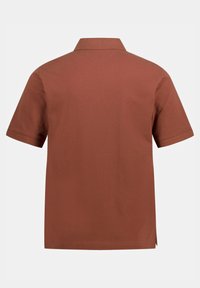 Polo shirt marrone a maniche corte con una morbida texture, colletto classico e spacchi laterali all'orlo per una maggiore libertà di movimento.