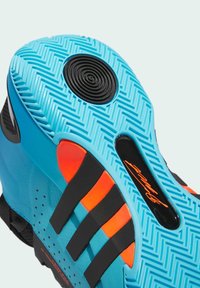 Semelle de chaussure de sport bleue présentant un motif en caoutchouc texturé, des accents noirs, des détails rouge-orangé et un point de traction circulaire noir.