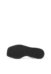 Suola in gomma nera con motivo testurizzato per la presa e bordo liscio; presenta un logo circolare vicino al tallone.