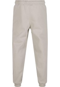 Gray cotton joggers feature an elastic waistband, tapered legs, and cuffed hems, with side pockets and a smooth texture.