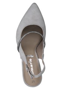 Harmaa mokkanahasta valmistettu kenkä, jossa on kärjessä terävä muoto ja nilkkaremmi, koristeltuna hopeanvärisillä glitterkoristeilla. Pehmeä rakenne ja yksinkertainen muotoilu, jossa on litteä pohja.