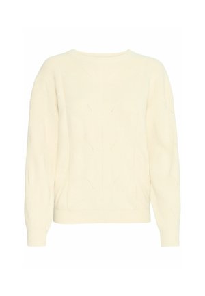 Kreminės spalvos megzta svandsukne su apvaliu iškirpimu, griovelio tekstūra ir deimanto raštais. Turi ilgomis rankovėmis ir prigludusį apatinius kraštus.