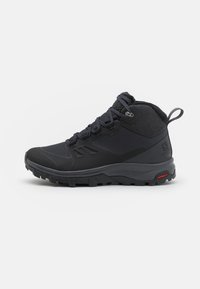 Bota de senderismo negra con un upper texturizado, puntera reforzada y suela de goma duradera con profundos surcos para tracción. Diseño con cordones.