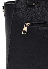 Black textured leather handbag with a small front zip pocket featuring a gold metal zipper pull tab.