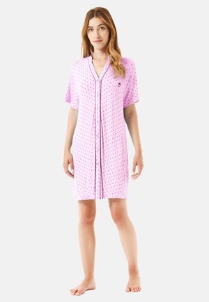 Camisón corto rosa con mangas cortas, cierre frontal de botones y un pequeño logo bordado. Presenta un patrón de lunares en tonos más oscuros.