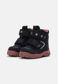Stivali invernali blu navy con fodera rosa, due cinturini in velcro, suole in gomma testurizzate e decorazioni a fiocco di neve sul materiale superiore.