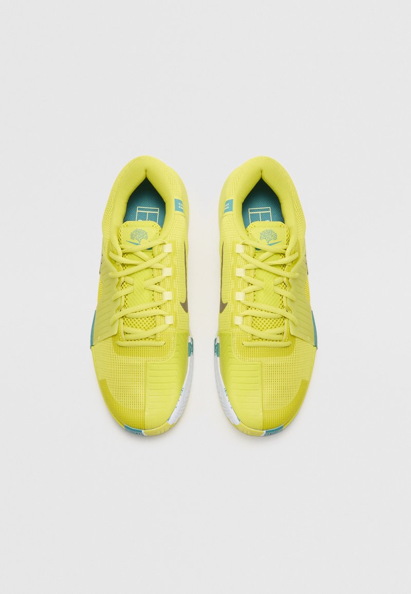 Scarpe da atletica di un vivace giallo con una parte superiore in rete traspirante, accenti blu e una suola texturizzata, dotate di lacci e di un logo sulla linguetta.