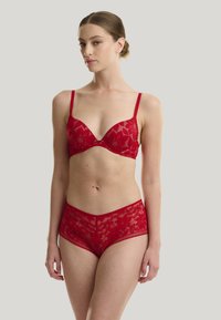 Rode kanten lingerieset met een bh met beugel en dunne bandjes, gecombineerd met bijpassende boyshorts, beide voorzien van bloemenpatronen.