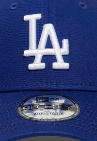 Μπλε καπέλο μπέιζμπολ με λευκό λογότυπο "LA". Διαθέτει δομημένο σχεδιασμό, ρυθμιζόμενο λουράκι και ετικέτα με το λογότυπο της New Era στην κάτω πλευρά του γείσου.
