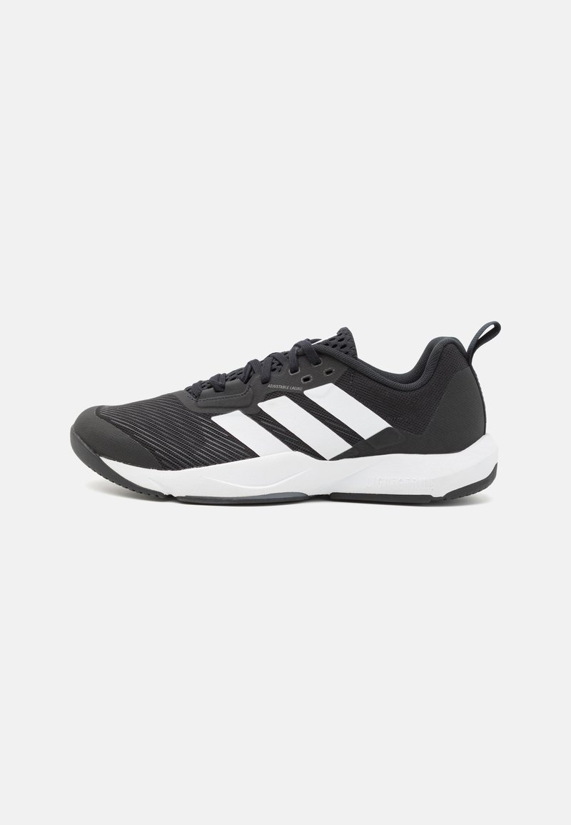 Zapatilla deportiva negra con rayas blancas, parte superior de malla texturizada, puntera reforzada y cuello acolchado. Cuenta con una suela de goma flexible para mayor tracción.