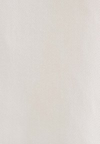 Tissu texturé blanc cassé avec un subtil motif diagonal. La surface semble lisse avec un léger éclat, mettant en valeur la consistance du matériau tissé.