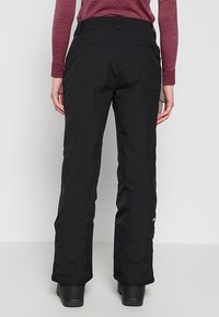 Zwarte skibroek met rechte pasvorm, gemaakt van waterdicht materiaal, voorzien van riemlussen en zijzakken. Versterkte zoom voor duurzaamheid.