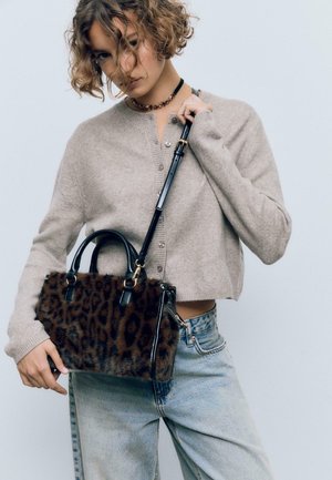 Leopard-print fur handbag with black leather accents, structured shape, short handles, and a detachable shoulder strap.