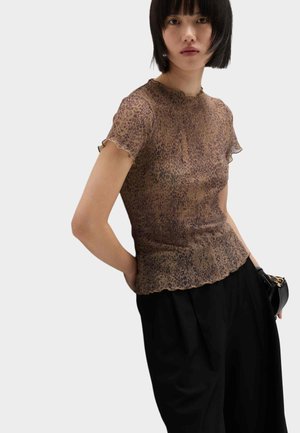 Hnědý top s leopardím potiskem, krátkými vlnitými rukávy, přiléhavým střihem a plisovaným detailem v pase, kombinovaný s černými širokými kalhotami.