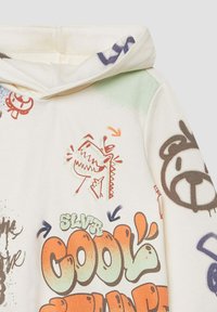 Kremowa bluza z kapturem z nadrukami w stylu graffiti, przedstawiająca wzory smoka i niedźwiedzia, z dodatkowym stylizowanym tekstem oraz kolorowymi akcentami.