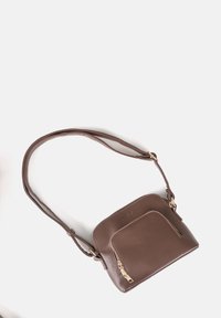 Borsa a tracolla in pelle marrone con un lungo manico regolabile, forma rettangolare, tasca zip anteriore e dettagli in metallo dorato.