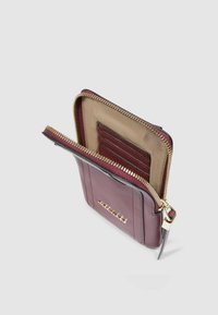 Portafoglio in pelle burgundy con cerniera dorata, dotato di più scomparti per carte, fodera interna color cuoio e logo in rilievo sul davanti.