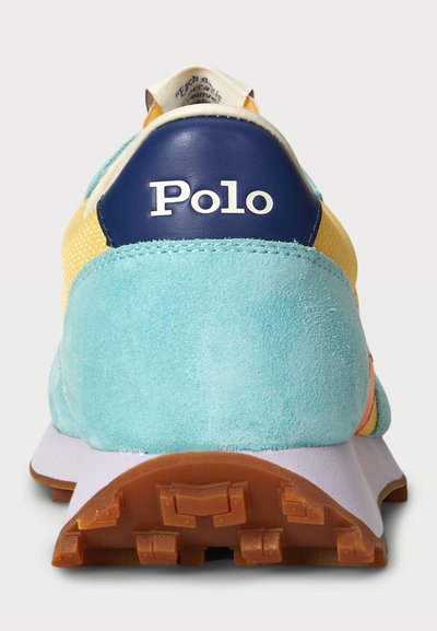 Turkiozu su mikrofibros paviršiumi, tamsiai mėlynu kulnu ir geltonais tinkliniais akcentais. Turintis guminį pado su traction nublizgininkais ir "Polo" logotipu ant kulno.