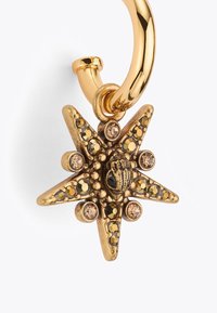 Boucle d'oreille en ton or avec un pendentif en forme d'étoile décoré de strass noirs et marron clair, et un design central de abeille.