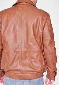 Brun läderjacka med en slät yta, som har en krage och ribbat avslut. Sömmar synliga på ryggen och ärmarna.