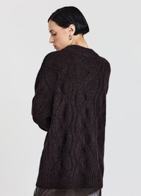 Brauner Strickpullover mit strukturiertem Wellenmuster, ausgestattet mit hohem Kragen und geripptem Saum. Der Stoff wirkt weich und grob gestrickt.